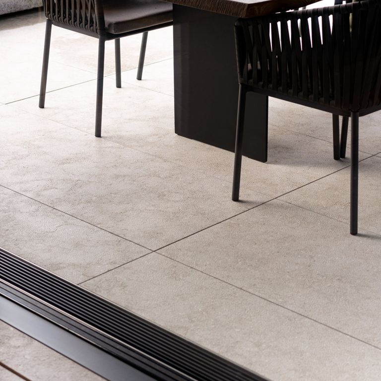 Application image for Veneto Olivo Limestone - Interior Flooring. The image shows this product being used in an interior floor application. The surface finish shown is leathered. The dominant color shown is gray; with beige, blue, brown and tan secondaries. The color mix creates a warm feeling. Cloudy color pattern. Contains mineral inclusions.