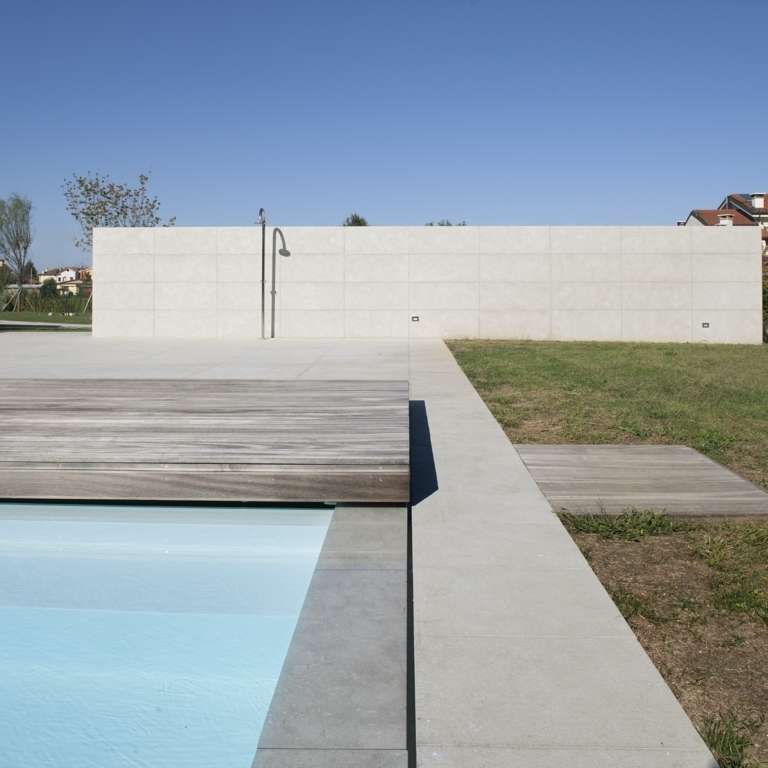 Application image for Veneto Olivo Limestone - Pool Coping. The image shows this product being used for pool coping and pool deck pavers. The surface finish shown is flamed. Dominant colors shown are beige and gray. The color mix creates a cool feeling.