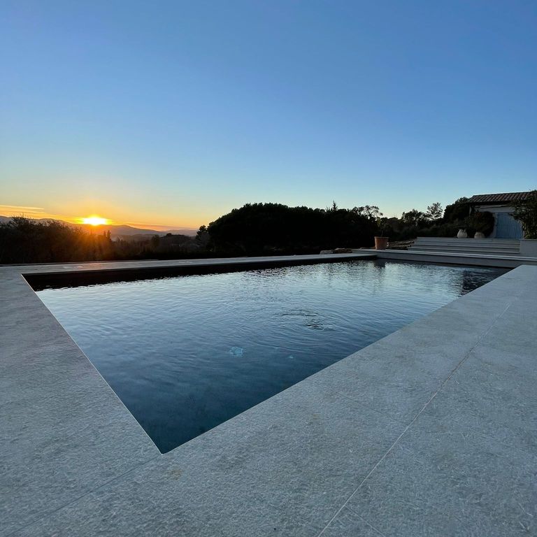 Application image for Veneto Olivo Limestone - Pool Coping. The image shows this product being used for pool coping and pool deck pavers. The surface finish shown is flamed. Dominant colors shown are gray and tan. The color mix creates a cool feeling.
