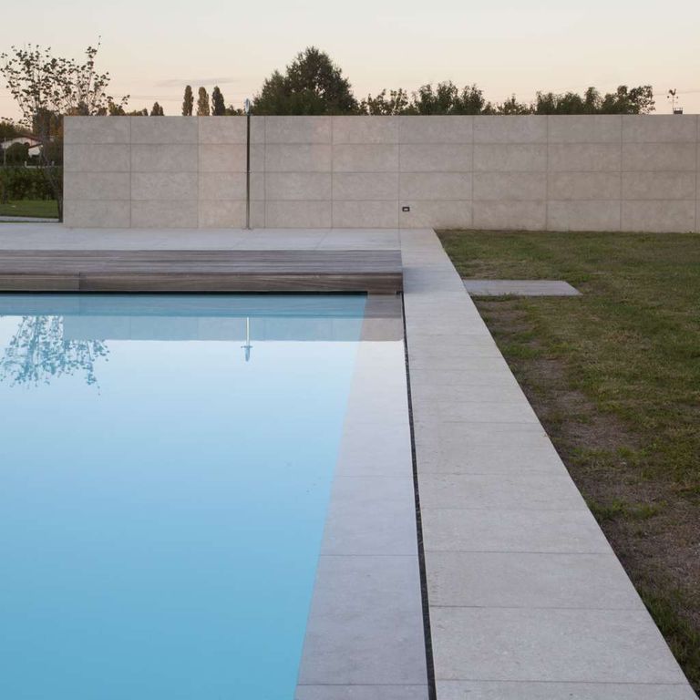Application image for Veneto Olivo Limestone - Pool Coping. The image shows this product being used in a pool coping application. The surface finish shown is flamed. Dominant colors shown are gray and tan. The color mix creates a cool feeling.
